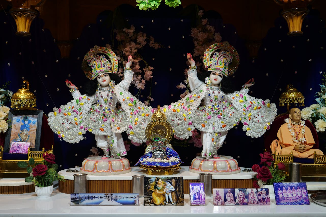 Offerings Vibrant decorative display featuring Krishna statues in a Hindu temple setting with cultural artifacts.