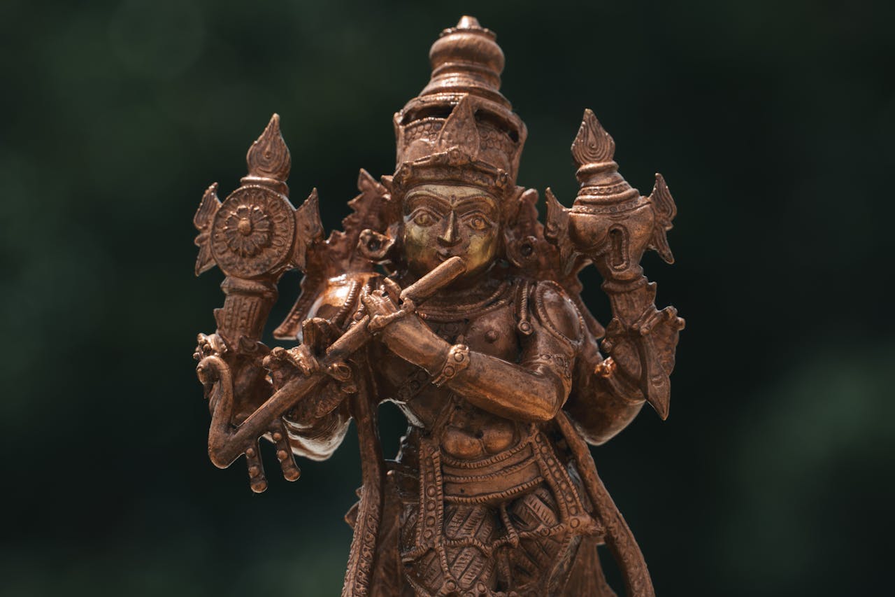 Home Close-up of an intricately designed brass sculpture of a Hindu deity, showcasing artistic craftsmanship from India.